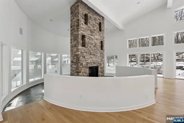 a living room with furniture a large window and wooden floor