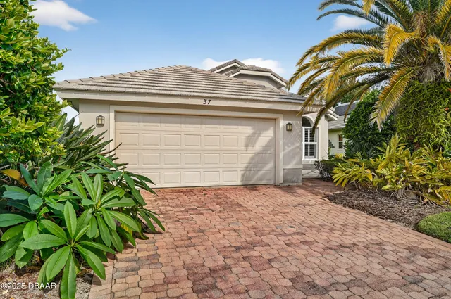 a white house with a small yard and plants