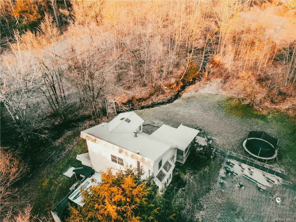 an aerial view of a house with yard and trees all around
