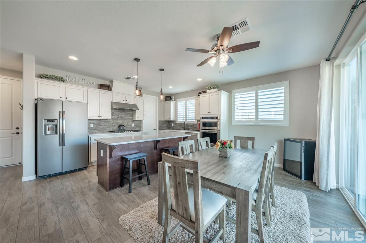 2935 Bonfire Lane Reno, NV 89521 - Photo 12 of 39 a kitchen with a dining table chairs refrigerator and cabinets