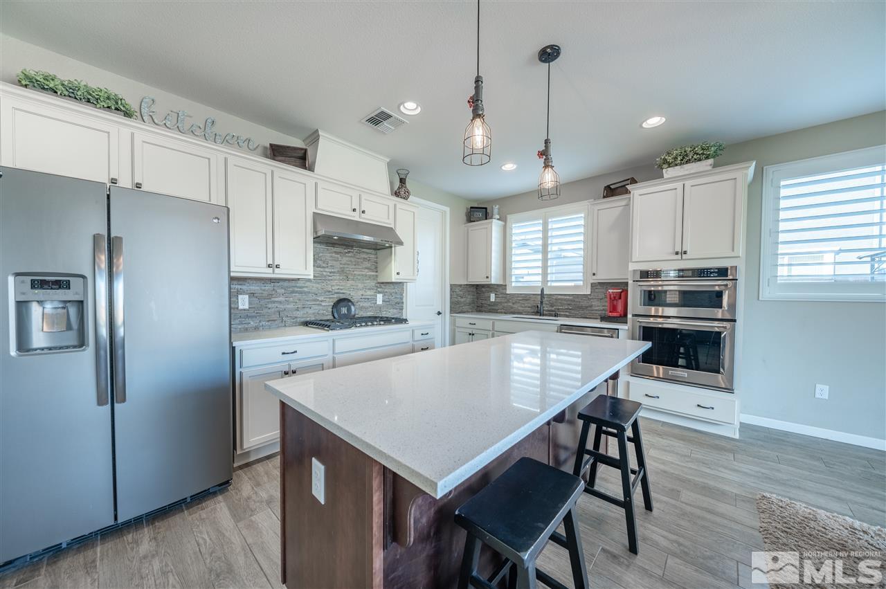 2935 Bonfire Lane Reno, NV 89521 - Photo 13 of 39 a kitchen with kitchen island a refrigerator stove microwave and cabinets