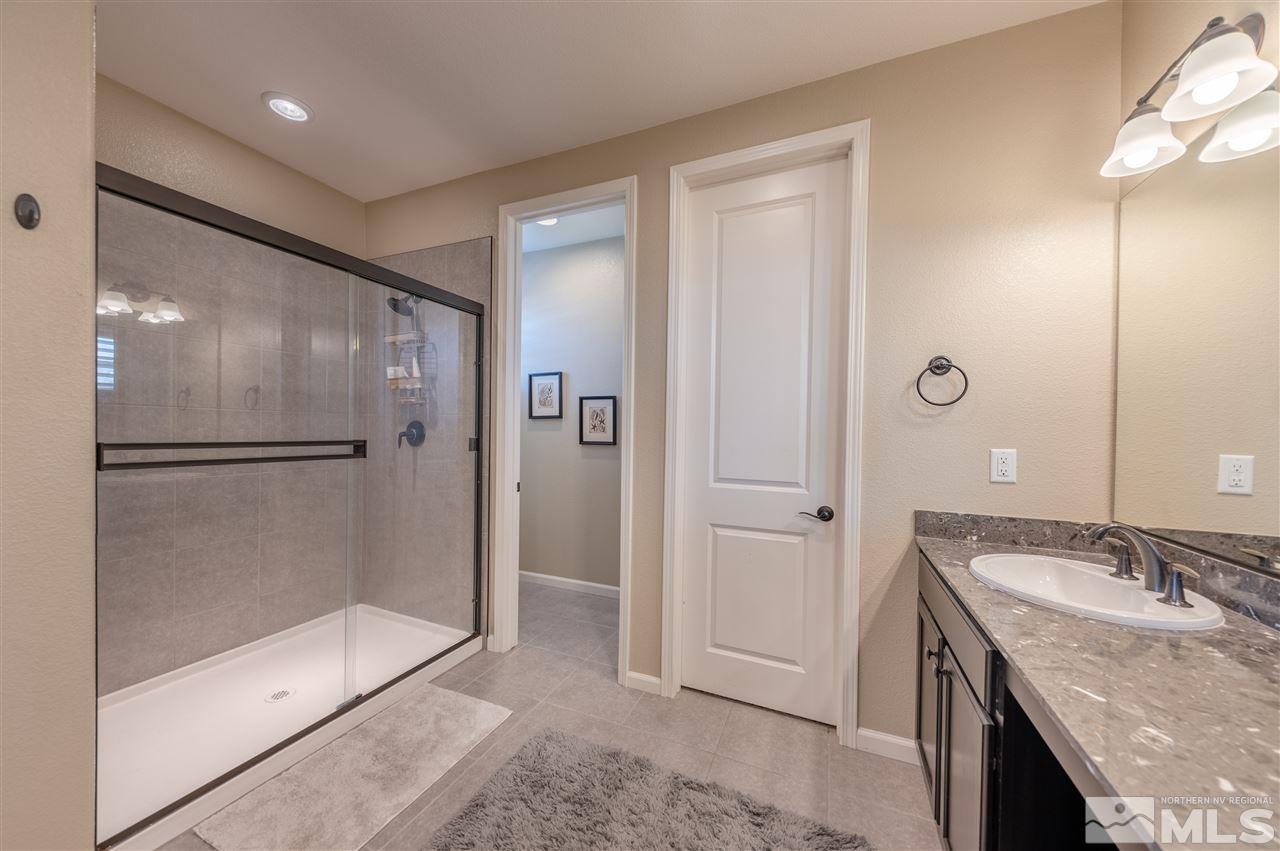 2935 Bonfire Lane Reno, NV 89521 - Photo 19 of 39 a bathroom with a granite countertop sink a shower and mirror