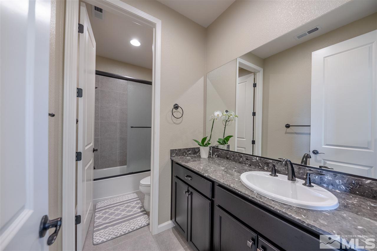 2935 Bonfire Lane Reno, NV 89521 - Photo 22 of 39 a bathroom with a granite countertop double vanity sink mirror and shower