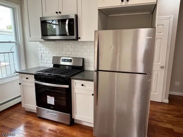 a kitchen with stainless steel appliances a refrigerator stove and microwave