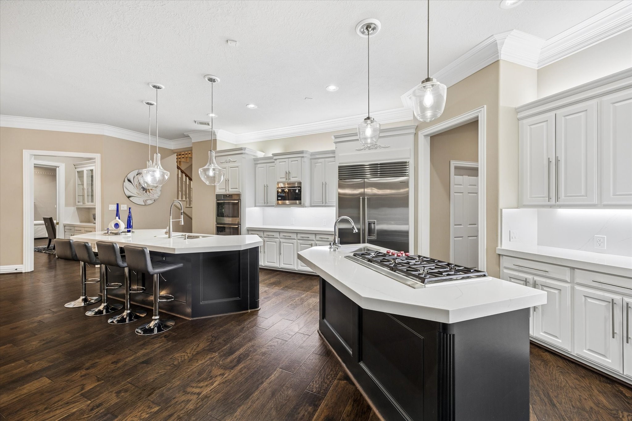 35 North Regent Oak Spring, TX 77381 - Photo 15 of 43 Sophisticated yet welcoming, this beautifully renovated kitchen offers the ideal blend of modern elegance and everyday livability. Dual islands provide ample space for meal preparation, casual dining, and entertaining, while quartz countertops, custom cabinetry, rich hardwood floors, and premium appliances elevate both form and function. A space designed to bring people together and create lasting memories.