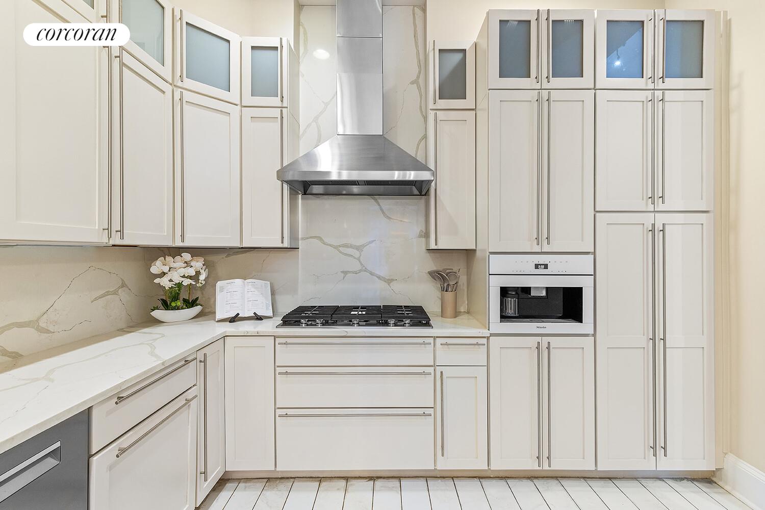 124 West 87th Street Manhattan, NY 10024 - Photo 7 of 37 a kitchen with stainless steel appliances white cabinets and a refrigerator