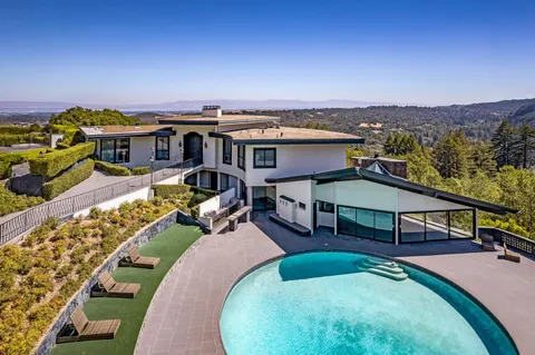 an aerial view of a house with swimming pool outdoor seating