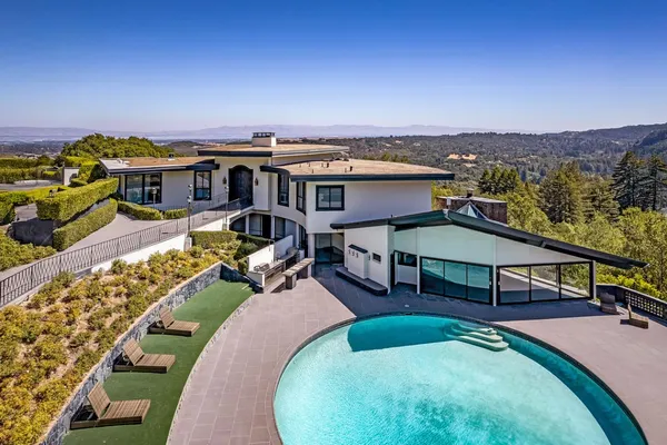 an aerial view of a house with swimming pool outdoor seating