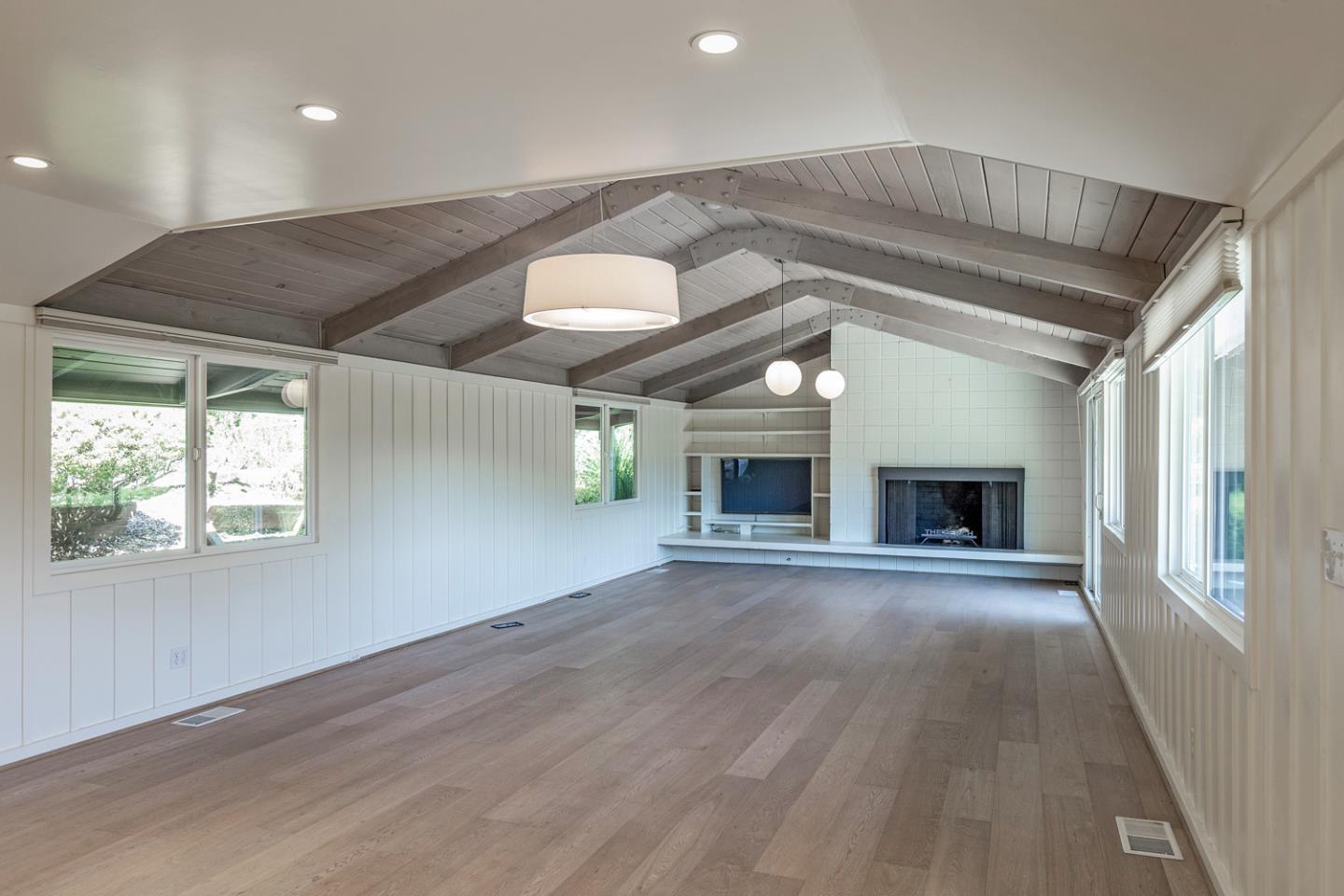 835 La Honda Road Woodside, CA 94062 - Photo 11 of 26 an empty room with wooden floor fireplace and windows