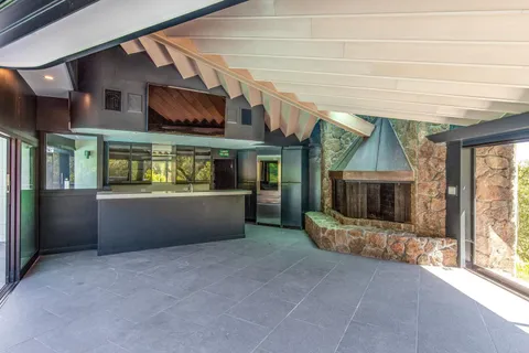 an empty room with a fireplace and outdoor view
