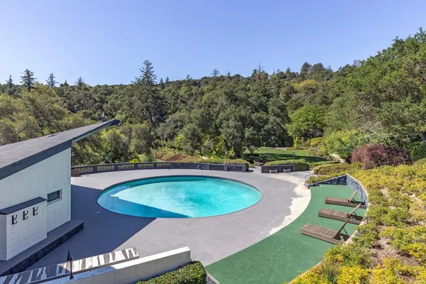 a view of a swimming pool with a yard and outdoor seating