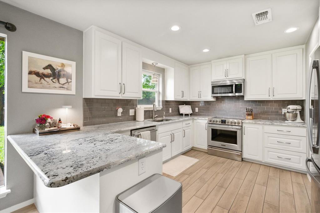1520 Timbercreek Road Benbrook, TX 76126 - Photo 13 of 30 a kitchen with granite countertop a sink cabinets stainless steel appliances and a counter space