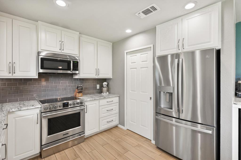1520 Timbercreek Road Benbrook, TX 76126 - Photo 15 of 30 a kitchen with stainless steel appliances wooden cabinets and a stove top oven