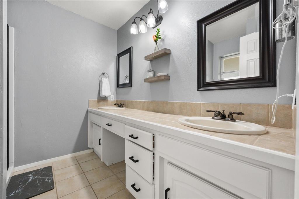 1520 Timbercreek Road Benbrook, TX 76126 - Photo 22 of 30 a bathroom with a sink and a mirror