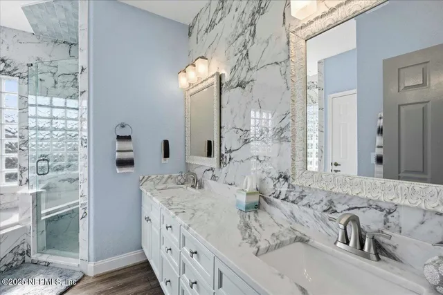 an aerial view of ocean and residential houses with outdoor space