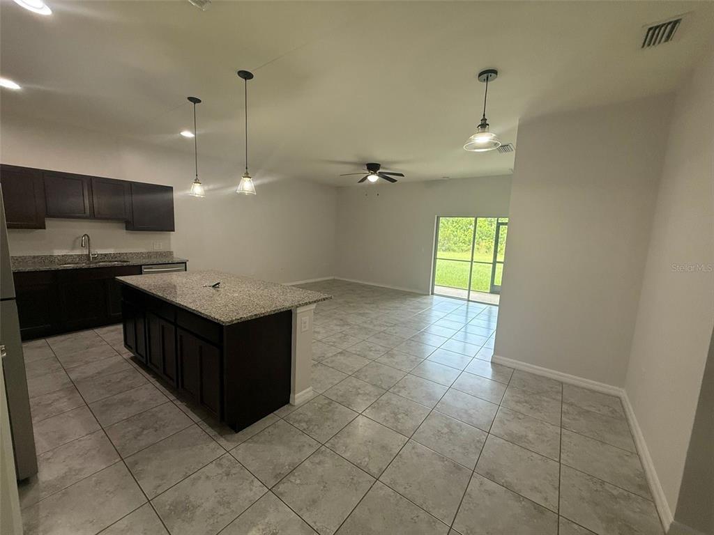 24484 Zephyr Court Punta Gorda, FL 33983 - Photo 3 of 22 a large kitchen with kitchen island a sink stainless steel appliances and a chandelier