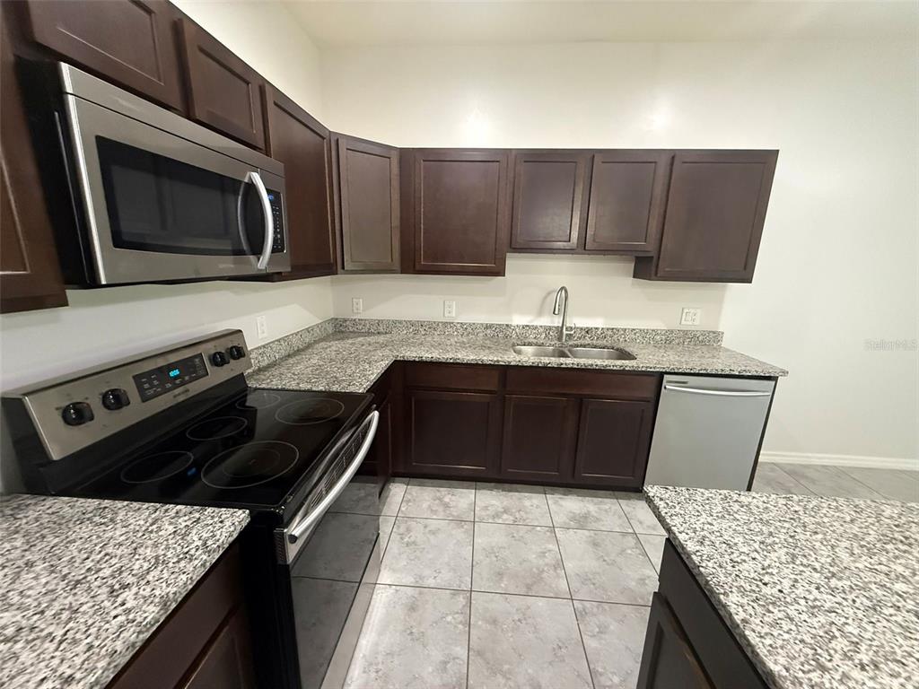 24484 Zephyr Court Punta Gorda, FL 33983 - Photo 6 of 22 a kitchen with a stove and a microwave