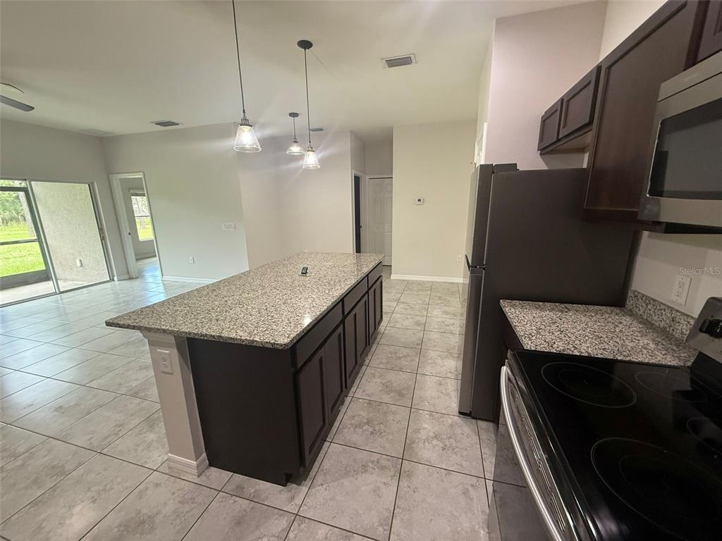 24484 Zephyr Court Punta Gorda, FL 33983 - Photo 7 of 22 a kitchen with granite countertop cabinets a sink and a stove