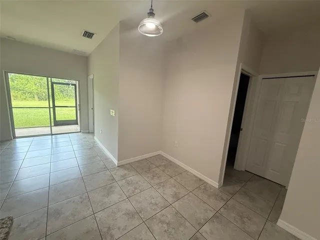 an empty room with windows and ceiling fan