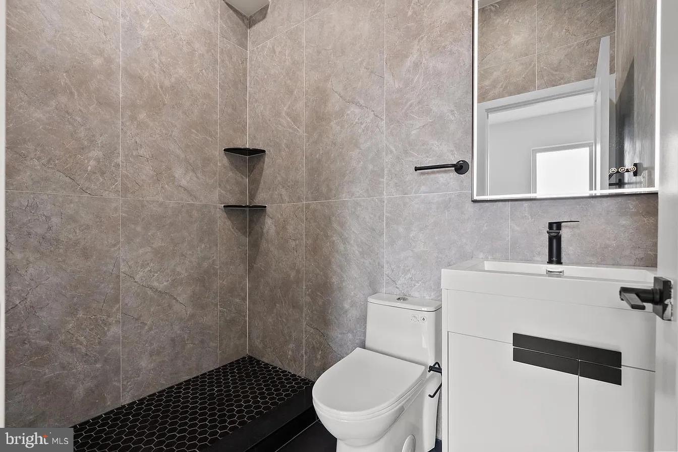 2146 North Front Street, Unit 3 Philadelphia, PA 19122 - Photo 21 of 23 a bathroom with a toilet a sink and mirror