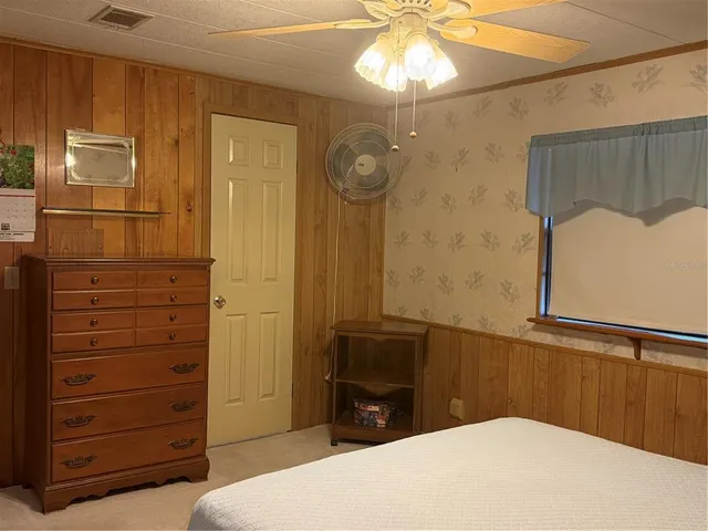 a bedroom with a bed and a painting on the wall