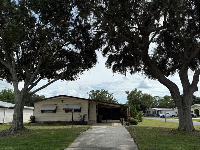a front view of a house with a garden and trees