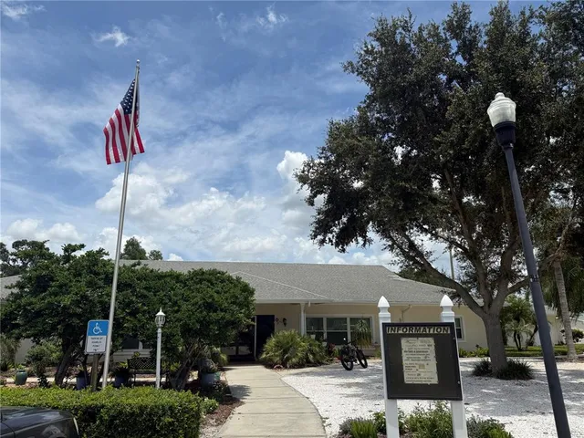 a view of a lake with table and chairs under an umbrella