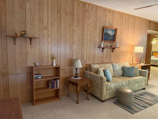 a living room with furniture a flat screen tv and a window