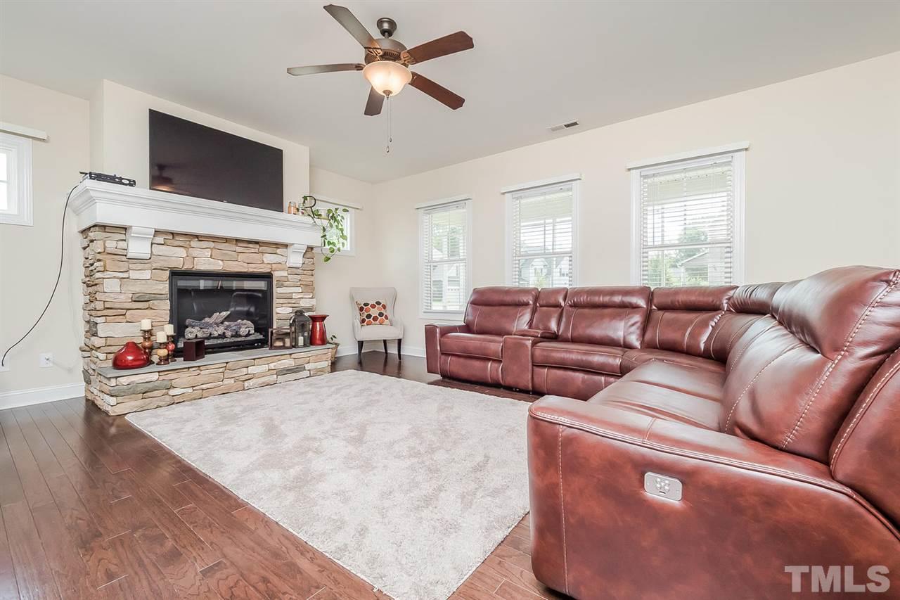 4436 Glengrove Road Raleigh, NC 27616 - Photo 4 of 25 a living room with couches a fireplace and a flat screen tv
