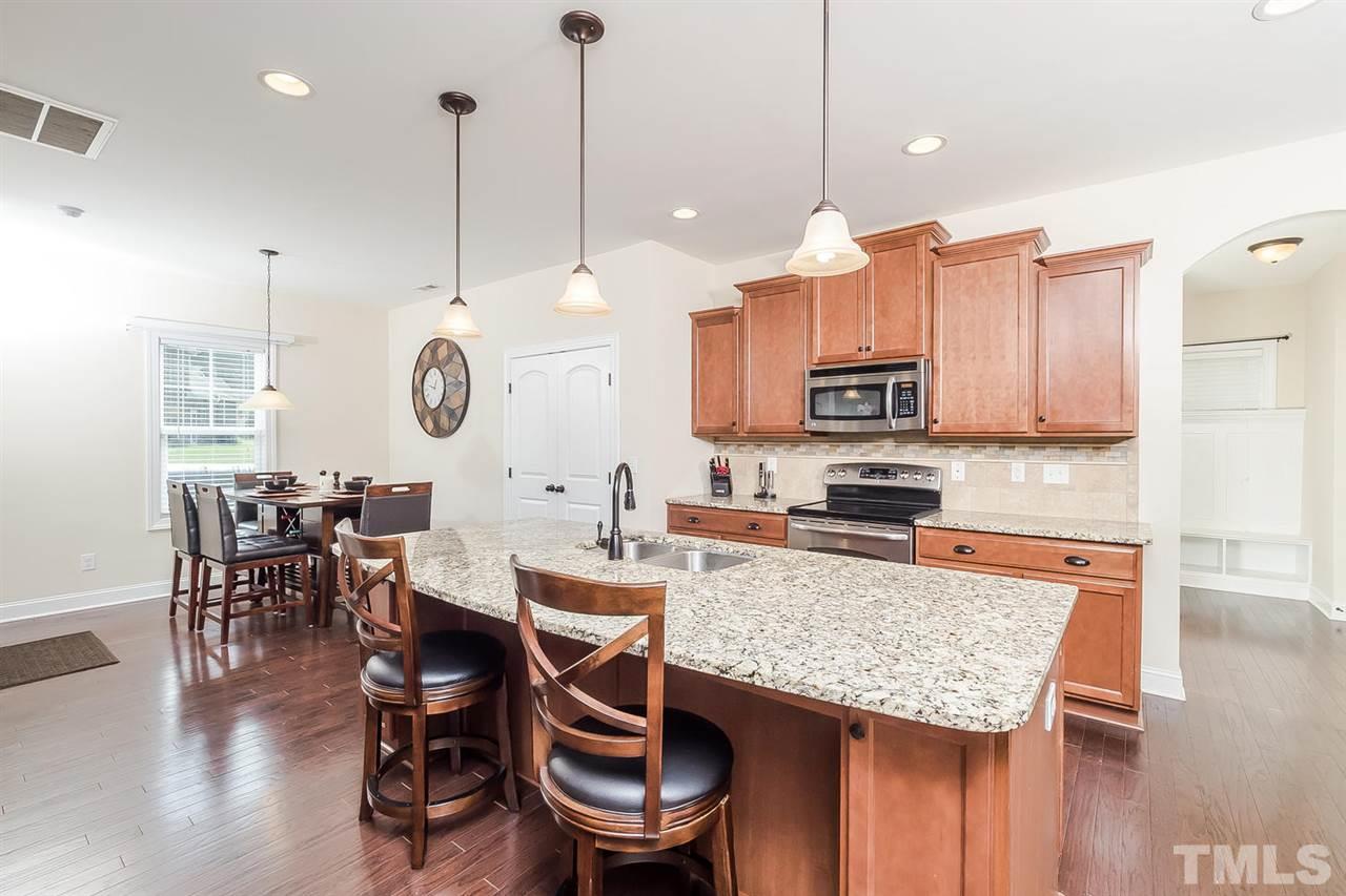 4436 Glengrove Road Raleigh, NC 27616 - Photo 7 of 25 a kitchen with stainless steel appliances granite countertop table chairs and a wooden floors