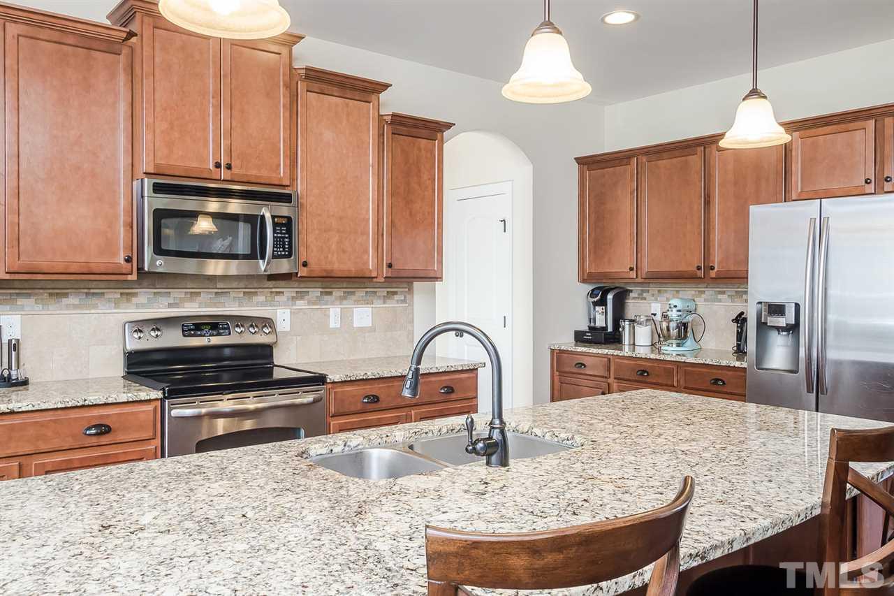 4436 Glengrove Road Raleigh, NC 27616 - Photo 8 of 25 a kitchen with granite countertop a stove a sink and a microwave