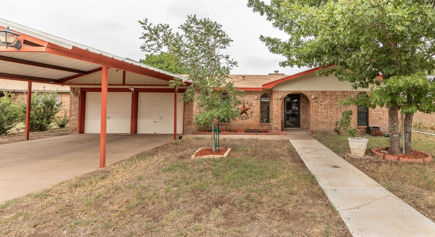 a backyard of a house with wooden fence and large trees