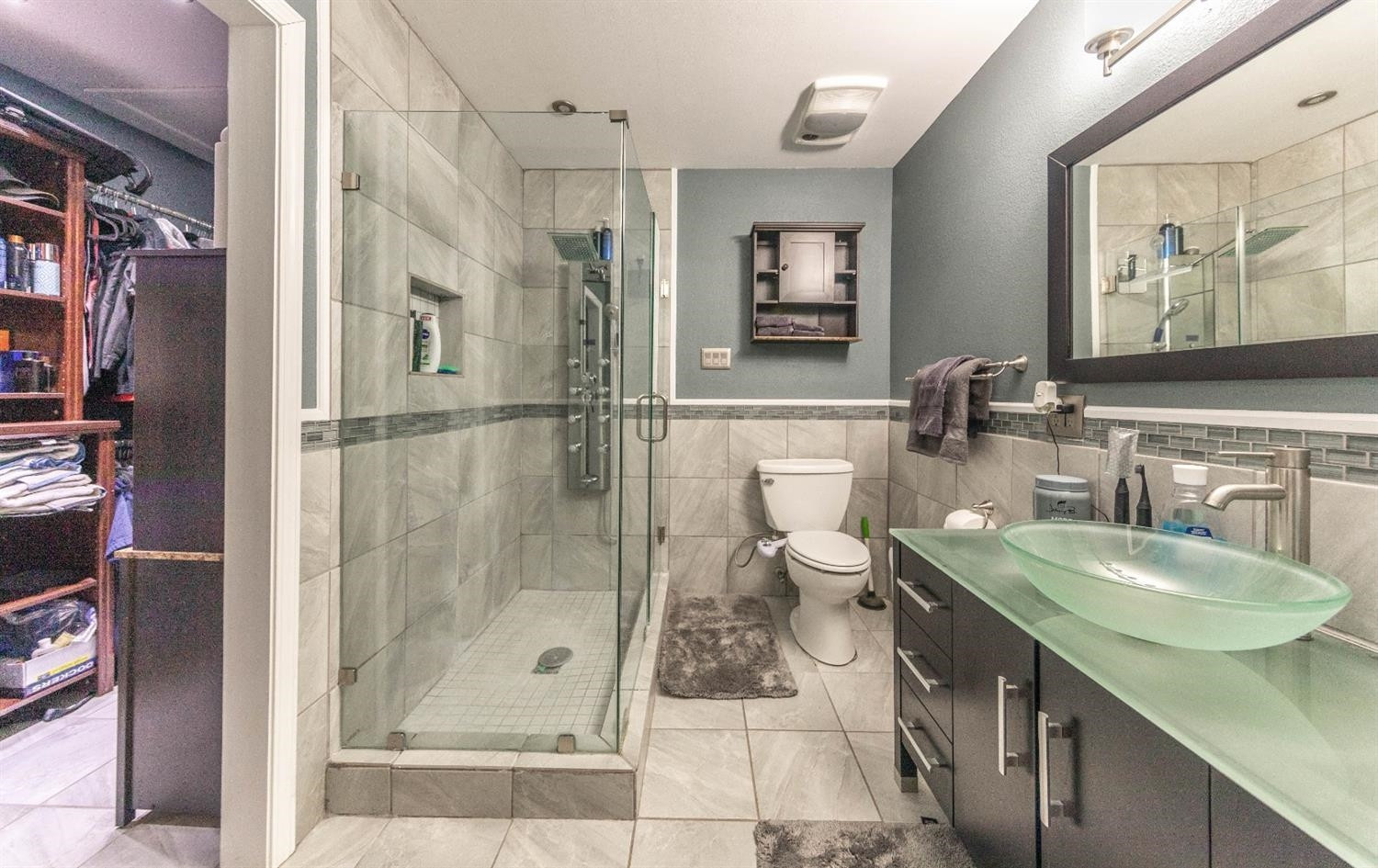 5722 2nd Place Lubbock, TX 79416 - Photo 13 of 21 a bathroom with a granite countertop sink a toilet a mirror and shower