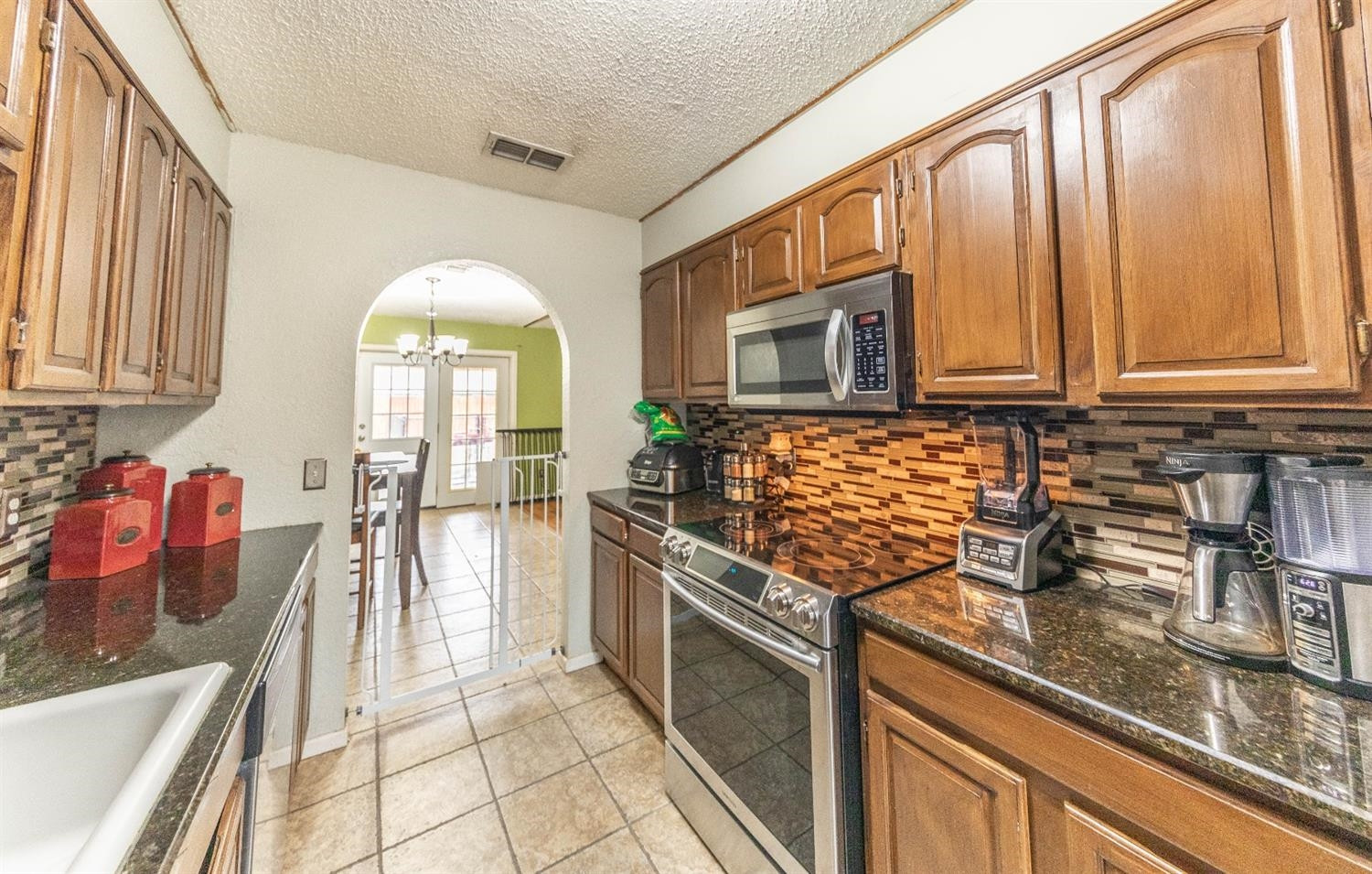 5722 2nd Place Lubbock, TX 79416 - Photo 3 of 21 a kitchen with stainless steel appliances granite countertop a stove a sink and a microwave