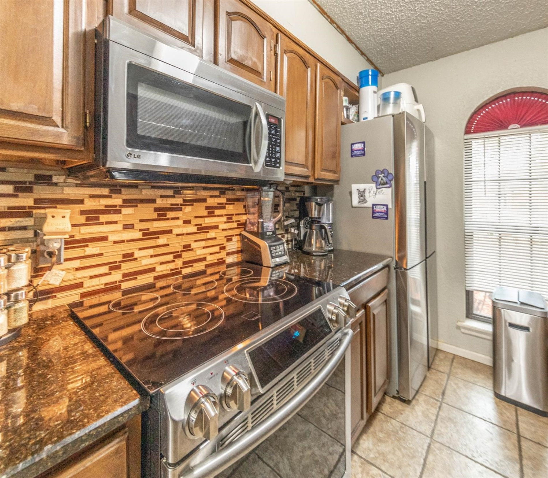 5722 2nd Place Lubbock, TX 79416 - Photo 5 of 21 a kitchen with stainless steel appliances granite countertop a stove and a microwave