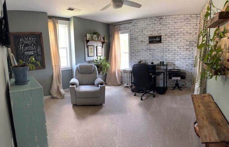 1897 Corbin Road Germantown, TN 38139 - Photo 15 of 22 Carpeted room featuring a ceiling fan, multiple windows with natural light, and a white-washed brick accent wall