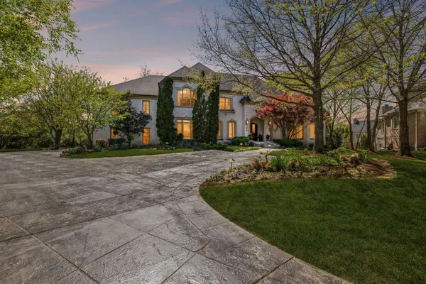 a kitchen with stainless steel appliances kitchen island granite countertop a table chairs sink and cabinets