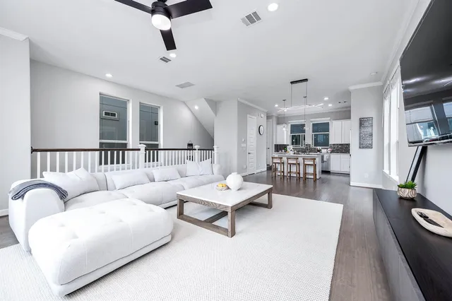 a living room with furniture and view of kitchen