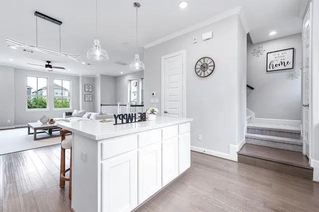 a kitchen with kitchen island white cabinets and stainless steel appliances