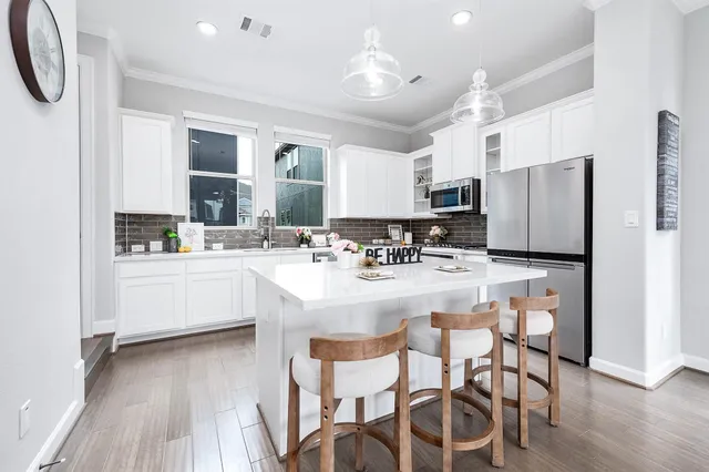 a kitchen with stainless steel appliances kitchen island granite countertop a refrigerator and a stove top oven