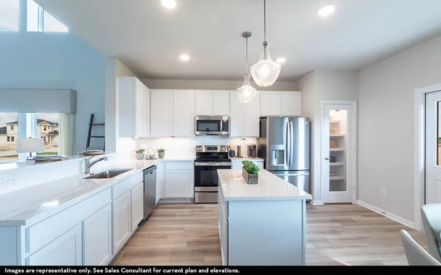 a kitchen with stainless steel appliances kitchen island granite countertop a sink stove and refrigerator