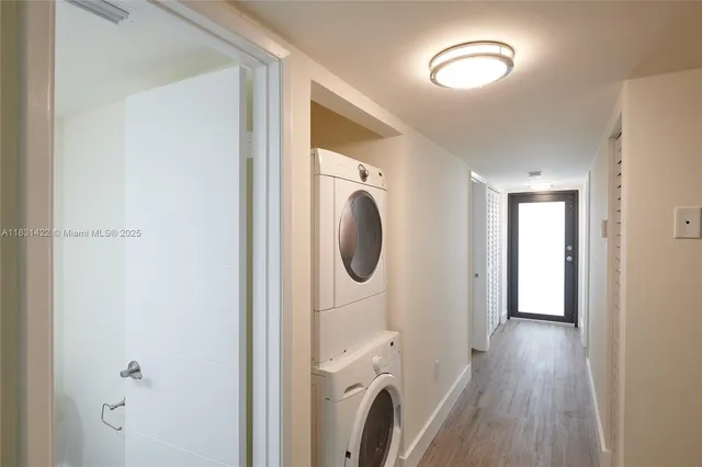 a view of a hallway with wooden floor and a washer