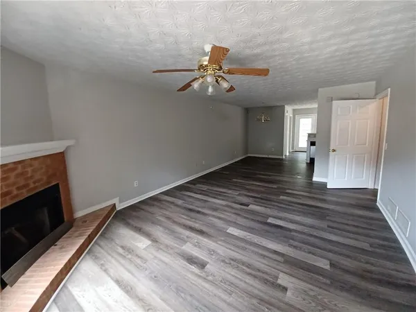 a view of a livingroom with wooden floor and a ceiling fan