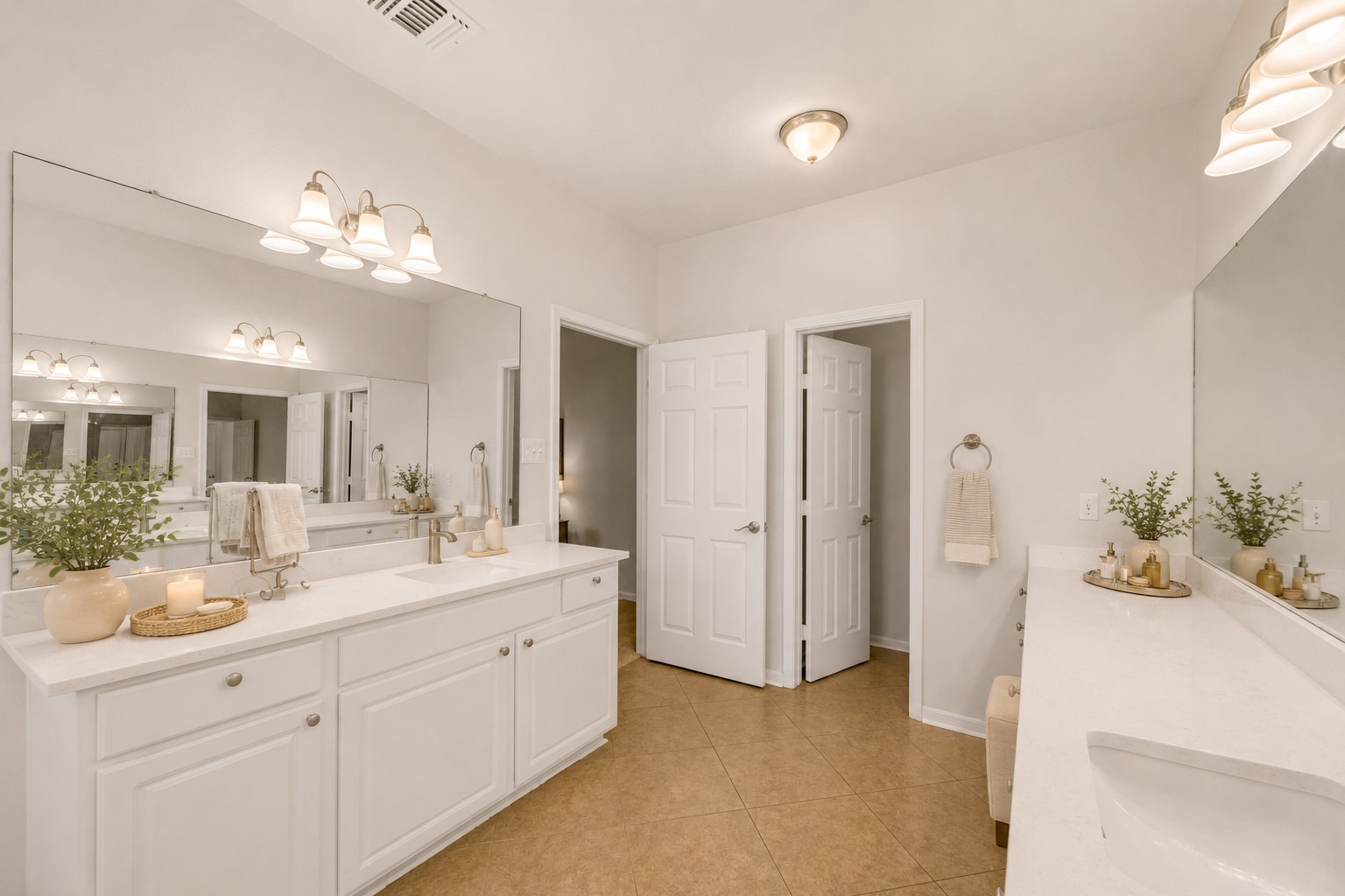 12528 Labrador Cove Austin, TX 78729 - Photo 29 of 40 Virtually Staged Primary Bathroom
This spacious primary bathroom offers a bright, spa-inspired retreat featuring dual quartz-topped vanities, expansive mirrors, abundant cabinetry, and elegant neutral finishes throughout. The virtually staged design showcases a light Pottery Barn aesthetic with soft textures, natural greenery, woven accents, and curated accessories that enhance the room’s luxurious scale while maintaining a clean, timeless feel. The oversized layout, generous counter space, and serene atmosphere create the perfect setting for daily routines and relaxation.
