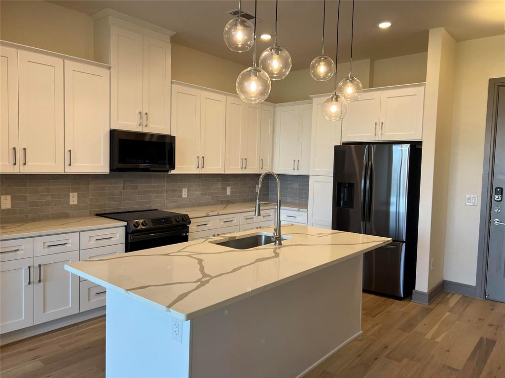 a kitchen with stainless steel appliances granite countertop a sink a refrigerator and a stove