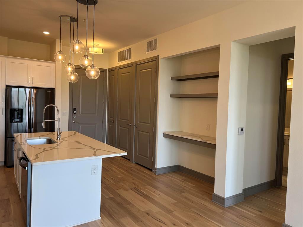 2700 Old Denton Road, Unit 4440 Carrollton, TX 75007 - Photo 2 of 16 a kitchen with kitchen island white cabinets and stainless steel appliances