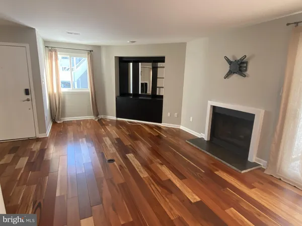 a view of a livingroom with wooden floor and a window