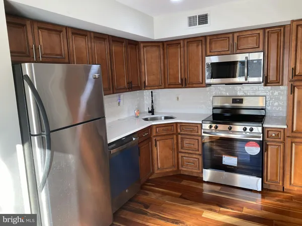 a kitchen with stainless steel appliances a refrigerator stove and microwave