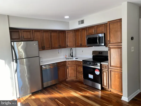 a kitchen with a refrigerator a stove top oven a sink and dishwasher