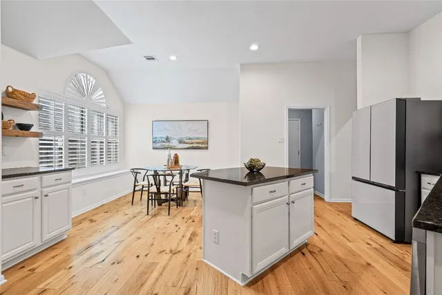 a kitchen with stainless steel appliances kitchen island granite countertop a refrigerator and microwave